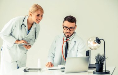 Hastanedeki doktor ortağıyla bilgisayar başında çalışıyor.