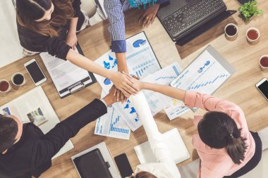 Takım çalışması çalışanları toplantıda el ele tutuşuyor.