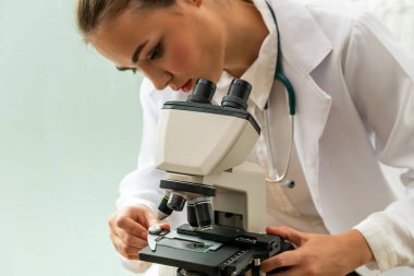 Hastane laboratuvarında mikroskop kullanan doktor.