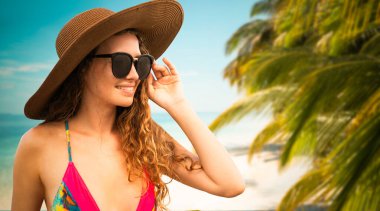 Yaz tatilinde sahilde mutlu genç kadın.