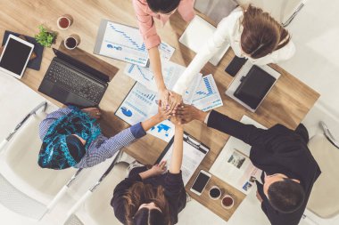 Takım çalışması çalışanları toplantıda el ele tutuşuyor.