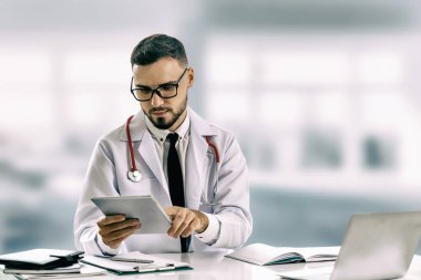 Hastanede tablet bilgisayar kullanan bir doktor..