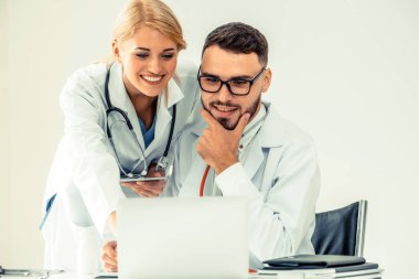 Hastanedeki doktor ortağıyla bilgisayar başında çalışıyor.