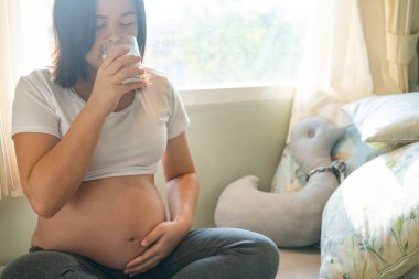 Mutlu hamile bir kadın ve evde bebek bekliyor..