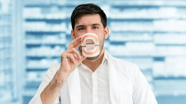 Young male dentist working in dental clinic.