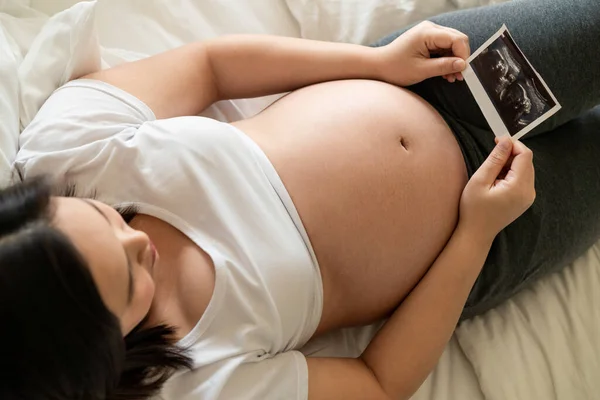 Mujer embarazada feliz y esperando un bebé en casa. — Foto de Stock