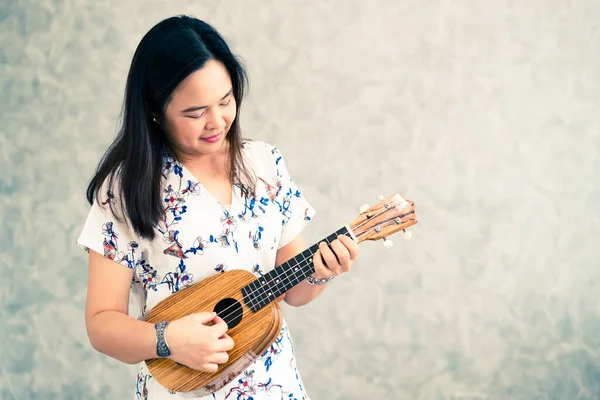 Mulher feliz músico tocando ukulele no estúdio . — Fotografia de Stock