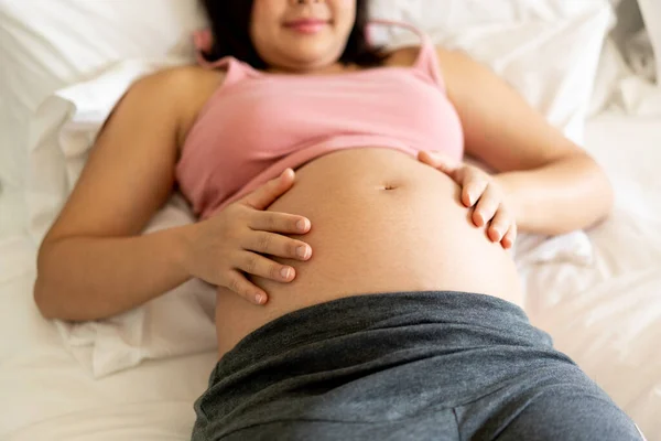 Mujer embarazada feliz y esperando un bebé en casa. — Foto de Stock