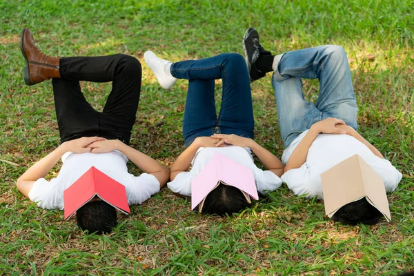 Estudiantes divertidos durmiendo con libros en la cara . — Foto de Stock