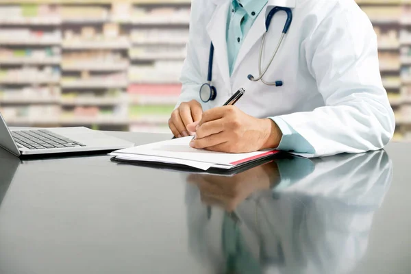 Farmacêutico escreve em documentos na farmácia . — Fotografia de Stock