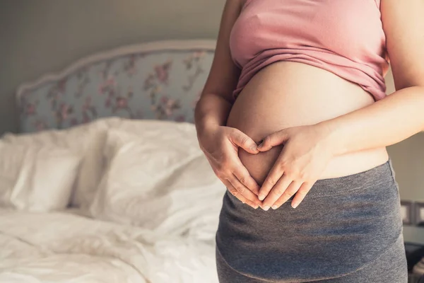 Mujer embarazada feliz y esperando un bebé en casa. — Foto de Stock