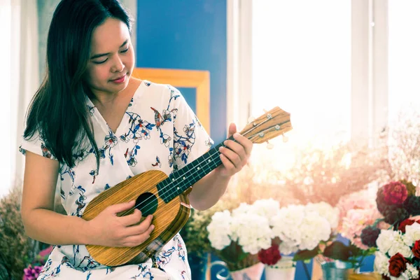 Mulher feliz músico tocando ukulele no estúdio . — Fotografia de Stock