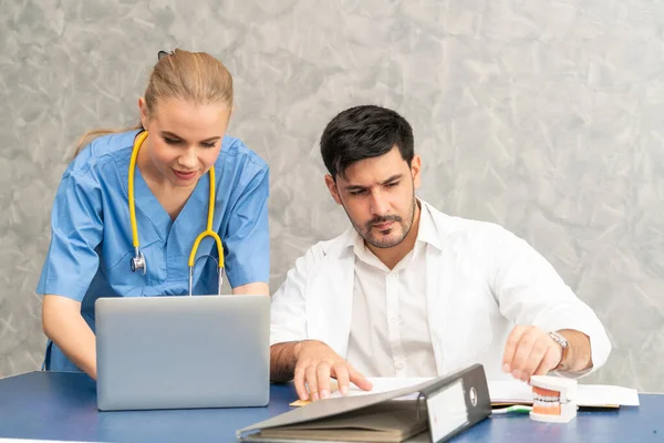 Médico e enfermeiro trabalhando com computador portátil . — Fotografia de Stock