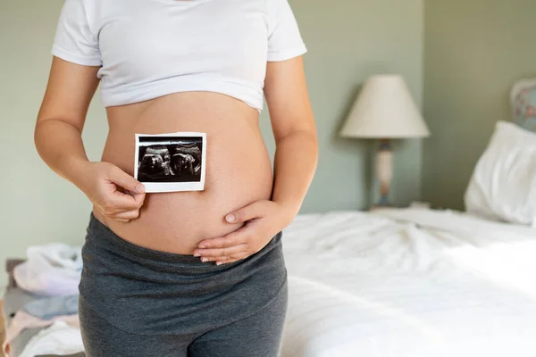 Mujer embarazada feliz y esperando un bebé en casa. — Foto de Stock