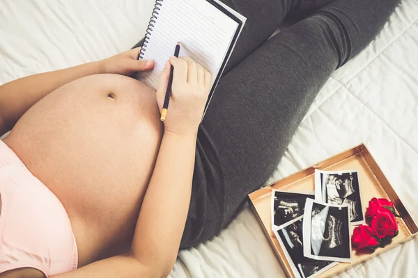 Mujer embarazada feliz y esperando un bebé en casa. — Foto de Stock