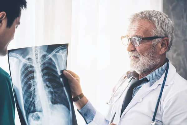 Médicos que trabajan con radiografías del tórax del paciente . — Foto de Stock