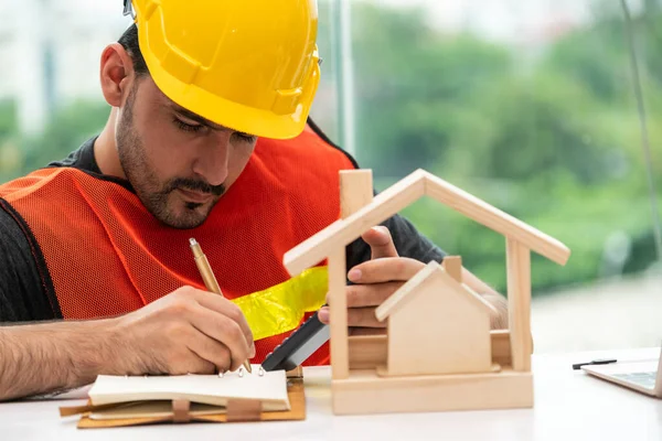 Ung man arkitekt eller ingenjör som arbetar vid skrivbordet. — Stockfoto