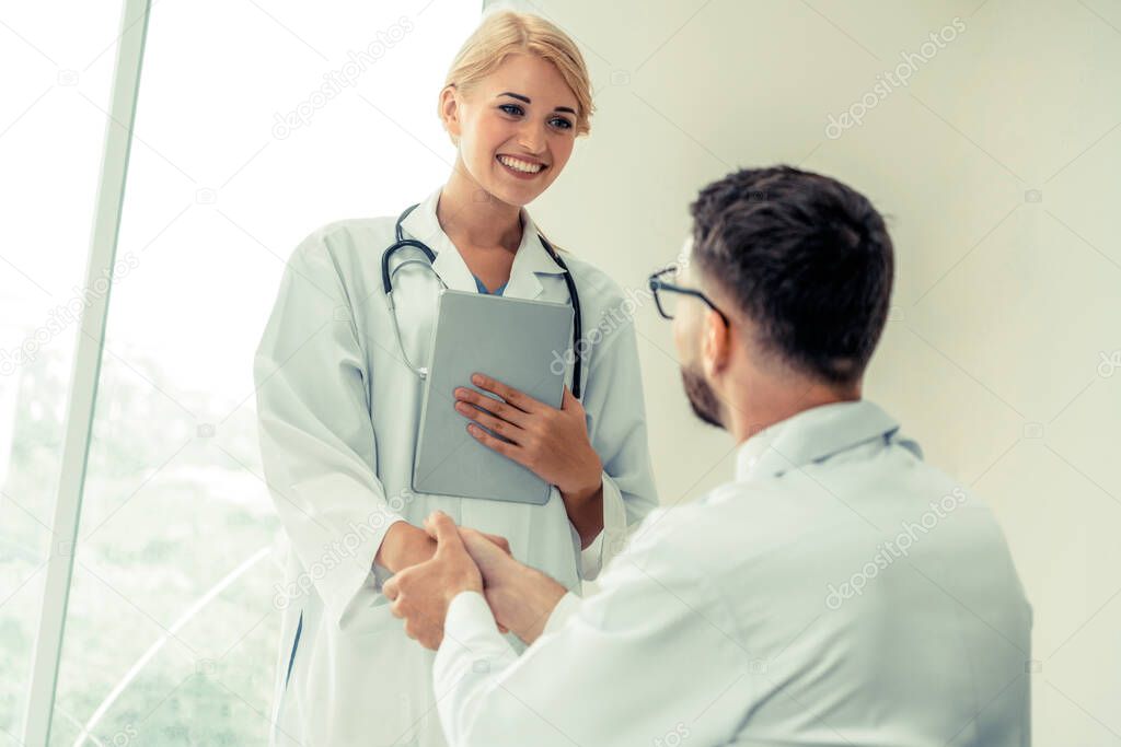 Doctor at hospital shakes hand with another doctor