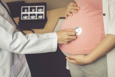 Mutlu hamile kadın hastanede jinekolog ya da hamilelik danışmanlığı için kliniği ziyaret ediyor.. 