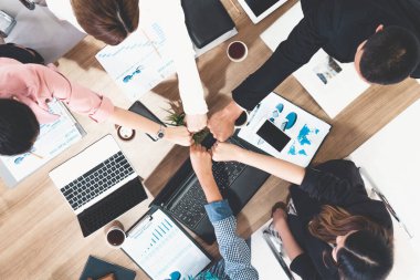 Takım çalışması çalışanları toplantıda el ele tutuşuyor.