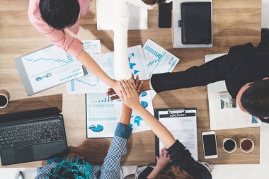 Takım çalışması çalışanları toplantıda el ele tutuşuyor.