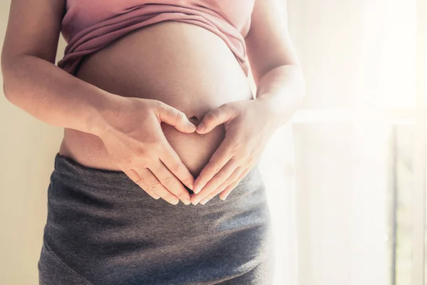 Mujer Embarazada Sintiéndose Feliz Casa Mientras Hace Señal Del Corazón — Foto de Stock