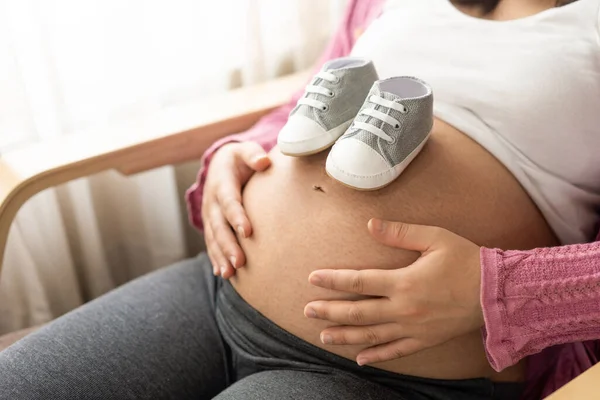 Mujer Embarazada Sintiéndose Feliz Casa Mientras Pone Zapatos Pequeños Vientre —  Fotos de Stock