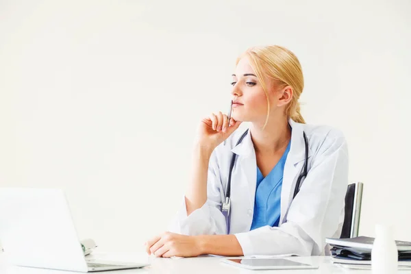 Woman doctor in hospital or healthcare institute working on medical report at office table.