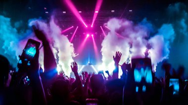 Mutlu insanlar gece kulübü DJ parti konserinde dans eder ve sahnede DJ 'den elektronik dans müziği dinlerler. Siluet dolu neşeli kalabalık 2020 yılbaşı partisini kutluyor. İnsanların yaşam tarzı DJ gece hayatı.