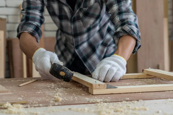 Marangoz atölyede ahşap işçiliği yapıyor. İnşaat malzemesi ya da ahşap mobilya üretiyor. Genç Asyalı marangoz zanaat için profesyonel araçlar kullanır. DIY üreticisi ve marangozluk konsepti.