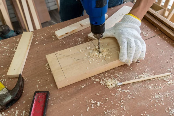 Marangoz atölyede ahşap işçiliği yapıyor. İnşaat malzemesi ya da ahşap mobilya üretiyor. Genç Asyalı marangoz zanaat için profesyonel araçlar kullanır. DIY üreticisi ve marangozluk konsepti.