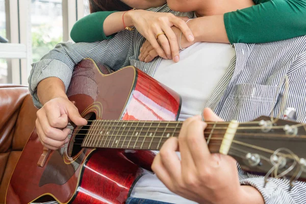 年轻的亚洲夫妇在家里客厅里一起弹奏吉他和唱歌 音乐与生活方式的概念 — 图库照片