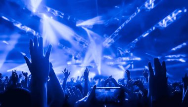 Mutlu insanlar gece kulübü DJ parti konserinde dans eder ve sahnede DJ 'den elektronik dans müziği dinlerler. Siluet dolu neşeli kalabalık 2020 yılbaşı partisini kutluyor. İnsanların yaşam tarzı DJ gece hayatı.