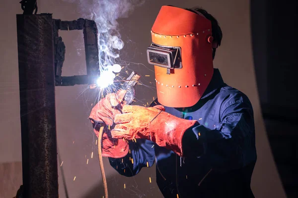 Metal welding steel works using electric arc welding machine to weld steel at factory. Metalwork manufacturing and construction maintenance service by manual skill labor concept.