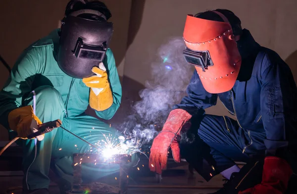 Metal welding steel works using electric arc welding machine to weld steel at factory. Metalwork manufacturing and construction maintenance service by manual skill labor concept.