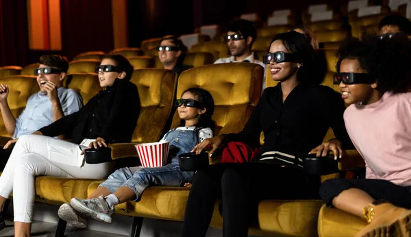 人々のグループは スクリーンを見て興味を持って映画館で3Dメガネで映画を見ます エキサイティングでポップコーンを食べて — ストック写真