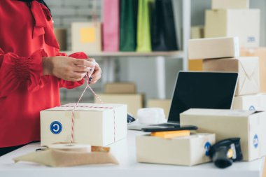 Çevrimiçi satıcı ev ofisinde çalışıyor ve teslimat kutusunu müşteriye paketliyor. İnternette e-ticaret yapan küçük işletme sahibi ya da girişimci.