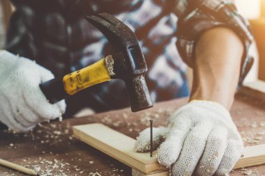 Marangoz atölyede ahşap işçiliği yapıyor. İnşaat malzemesi ya da ahşap mobilya üretiyor. Genç Asyalı marangoz zanaat için profesyonel araçlar kullanır. DIY üreticisi ve marangozluk konsepti.