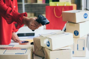 Çevrimiçi satıcı ev ofisinde çalışıyor ve teslimat kutusunu müşteriye paketliyor. İnternette e-ticaret yapan küçük işletme sahibi ya da girişimci.