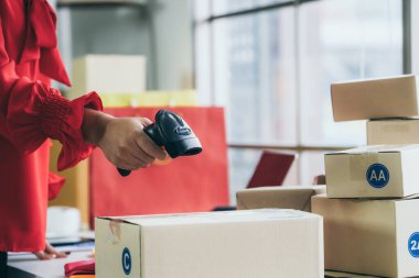 Çevrimiçi satıcı ev ofisinde çalışıyor ve teslimat kutusunu müşteriye paketliyor. İnternette e-ticaret yapan küçük işletme sahibi ya da girişimci.