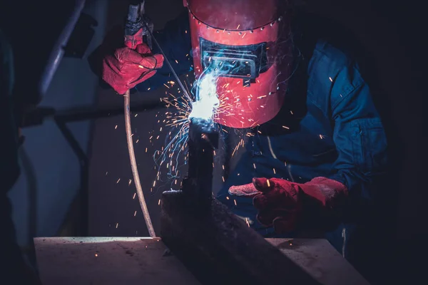 Metal welding steel works using electric arc welding machine to weld steel at factory. Metalwork manufacturing and construction maintenance service by manual skill labor concept.