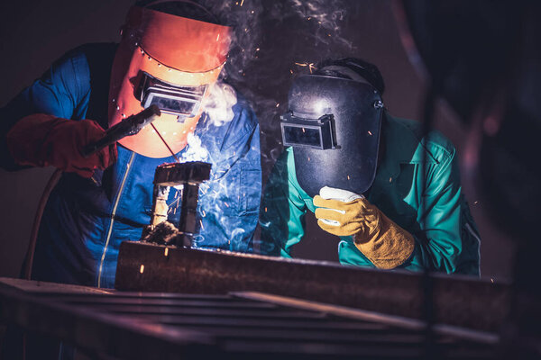 Metal welding steel works using electric arc welding machine to weld steel at factory. Metalwork manufacturing and construction maintenance service by manual skill labor concept.