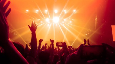 Mutlu insanlar gece kulübü DJ parti konserinde dans eder ve sahnede DJ 'den elektronik dans müziği dinlerler. Siluet dolu neşeli kalabalık 2020 yılbaşı partisini kutluyor. İnsanların yaşam tarzı DJ gece hayatı.