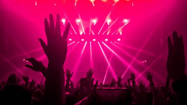 Mutlu insanlar gece kulübü DJ parti konserinde dans eder ve sahnede DJ 'den elektronik dans müziği dinlerler. Siluet dolu neşeli kalabalık 2020 yılbaşı partisini kutluyor. İnsanların yaşam tarzı DJ gece hayatı.