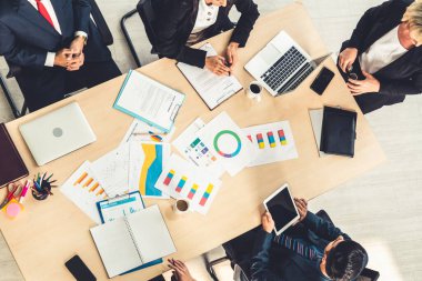 İş adamları grup toplantısı ofiste yukarıdan çekildi. İş kadınları, iş adamları ve ofis çalışanları, proje planlama belgeleriyle takım konferansında toplantı masasında çalışıyorlar. .