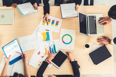İş adamları grup toplantısı ofiste yukarıdan çekildi. İş kadınları, iş adamları ve ofis çalışanları, proje planlama belgeleriyle takım konferansında toplantı masasında çalışıyorlar. .