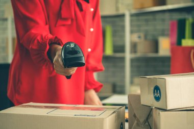 Çevrimiçi satıcı ev ofisinde çalışıyor ve teslimat kutusunu müşteriye paketliyor. İnternette e-ticaret yapan küçük işletme sahibi ya da girişimci.