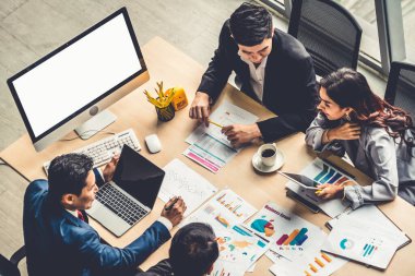 İş adamları grup toplantısı ofiste yukarıdan çekildi. İş kadınları, iş adamları ve ofis çalışanları, proje planlama belgeleriyle takım konferansında toplantı masasında çalışıyorlar. .