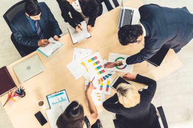 İş adamları grup toplantısı ofiste yukarıdan çekildi. İş kadınları, iş adamları ve ofis çalışanları, proje planlama belgeleriyle takım konferansında toplantı masasında çalışıyorlar. .
