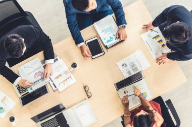 İş adamları grup toplantısı ofiste yukarıdan çekildi. İş kadınları, iş adamları ve ofis çalışanları, proje planlama belgeleriyle takım konferansında toplantı masasında çalışıyorlar. .